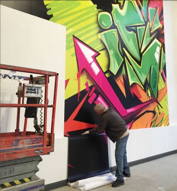 Jim Spelman installs a giant wall mural at Irontek using Solvent Print-N-Stick
